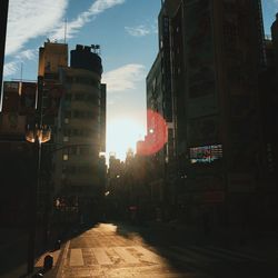 Street amidst buildings in city during sunset