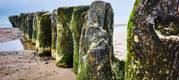Panoramic shot of rocks on beach against sky