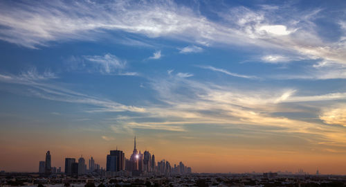 Buildings in city against cloudy sky