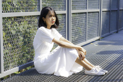 Portrait of young woman sitting outdoors