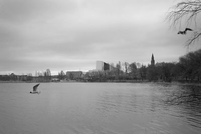 Scenic view of lake by city against sky