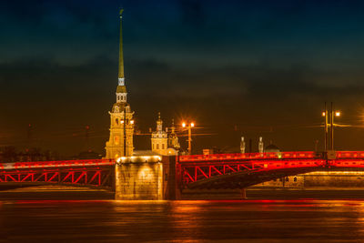 Illuminated tower bridge against sky at night