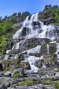 Low angle view of waterfall on rocks