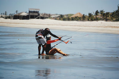 Kite school. woman at first lesson of kitesurf with her teacher in the beach