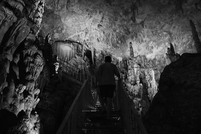 Rear view of people walking in cave