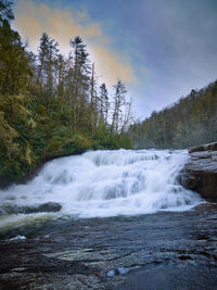 Scenic view of waterfall against sky