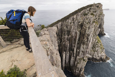 Man standing on rock by sea