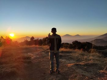 Rear view of man looking at sunset