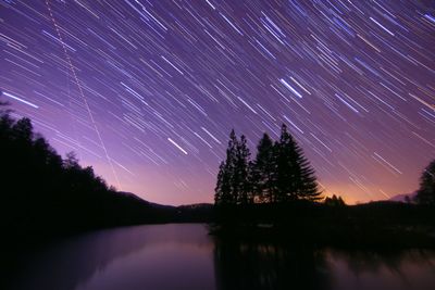 Scenic view of lake against sky at night