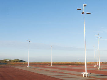 Street lights on road against sky