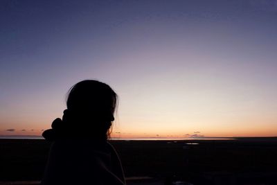 Rear view of silhouette man standing against clear sky
