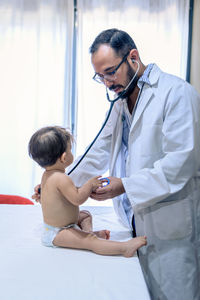 Doctor observing a one-year-old baby