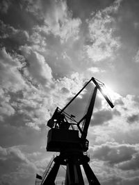 Low angle view of crane at construction site against sky