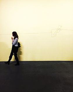 Full length of young woman standing by railing