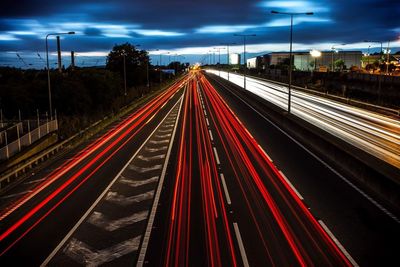 Light trails on road against sky at night