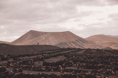 Scenic view of volcanic landscape against cloudy sky