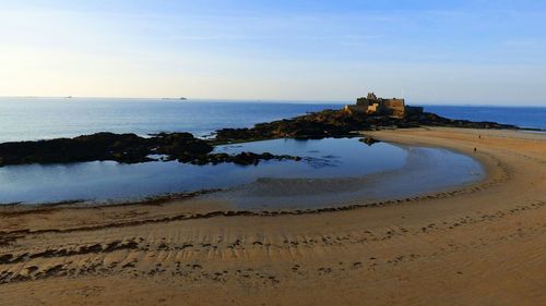 View of calm beach against blue sky