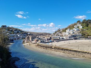 Panoramic view of beach and buildings against blue sky