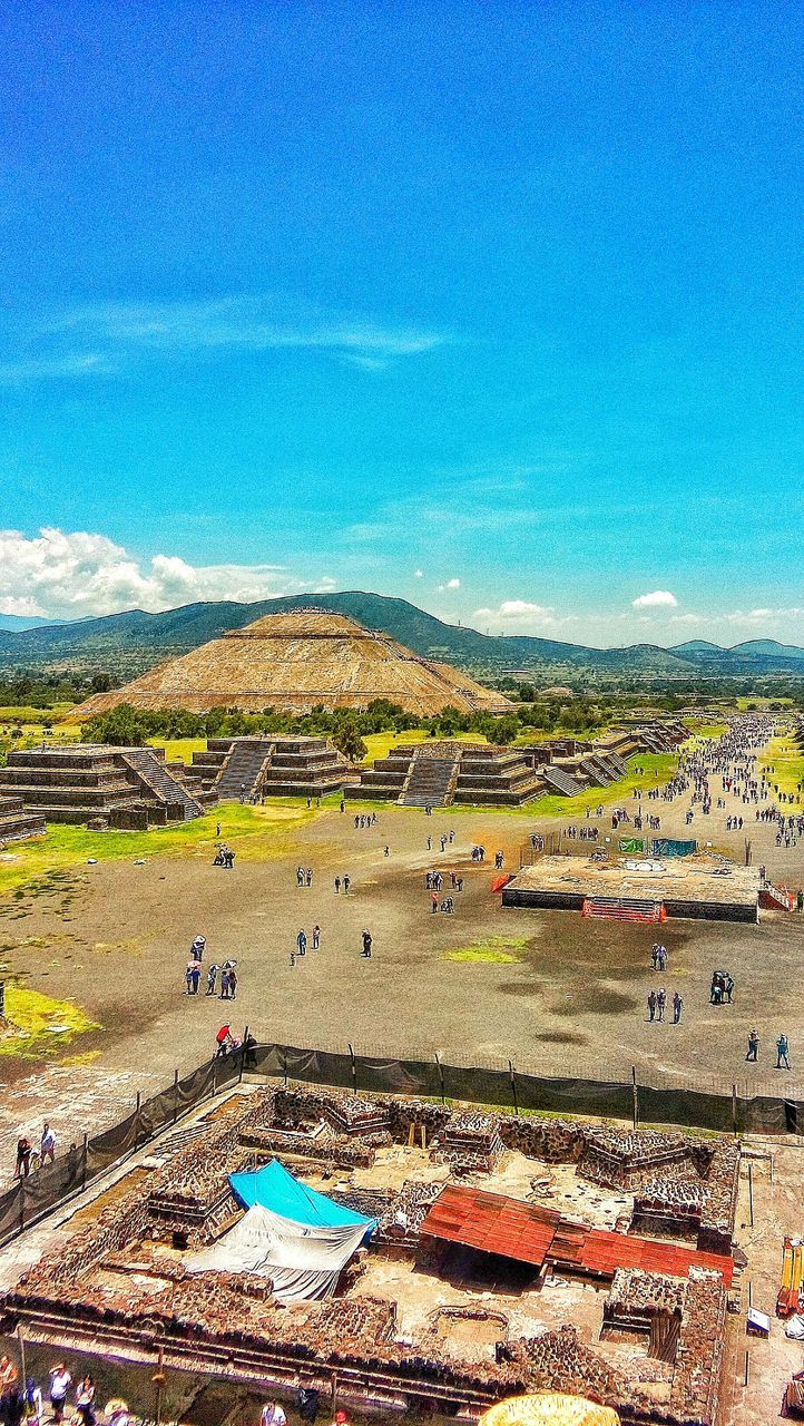 landscape, blue, high angle view, tranquil scene, tranquility, scenics, sky, beauty in nature, field, rural scene, built structure, horizon over land, nature, building exterior, agriculture, architecture, aerial view, travel destinations, mountain, day