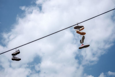 Low angle view of man hanging on pole against sky