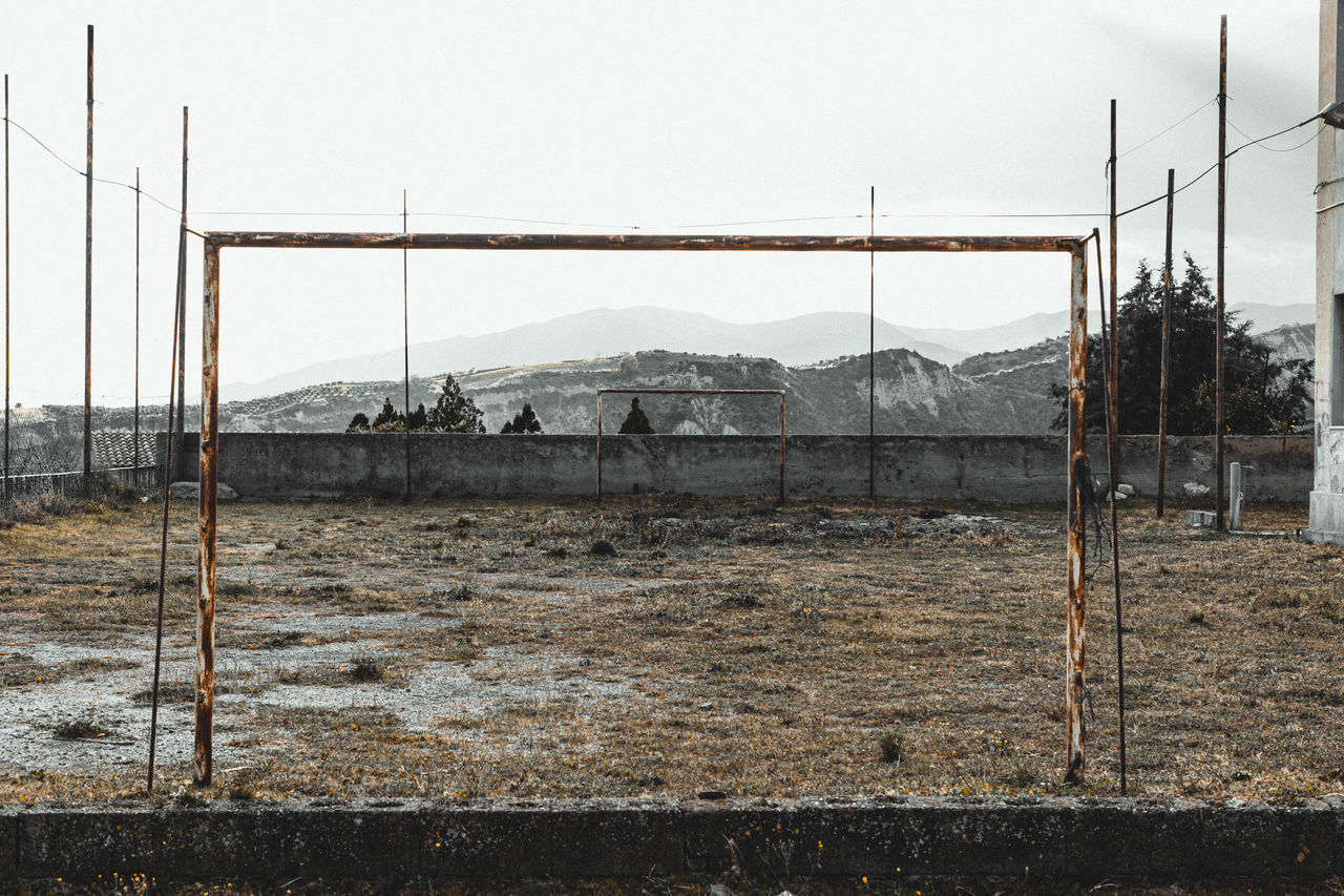 ABANDONED CAR ON FIELD AGAINST SKY