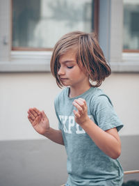 Cute girl playing while standing against wall