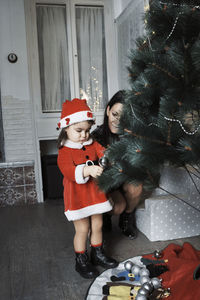 Rear view of girl and christmas tree