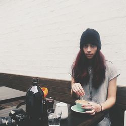 Portrait of woman having coffee while sitting at cafe
