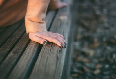 Close-up of man hand on wooden plank