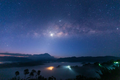 Scenic view of illuminated mountains against sky at night