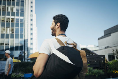 Rear view of happy tourist in city