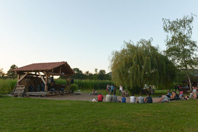 People relaxing on grassy field
