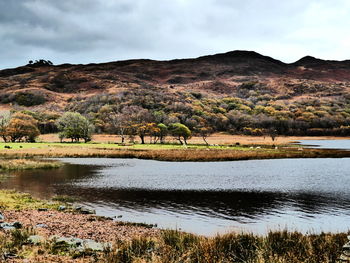 Scenic view of lake by mountain against sky