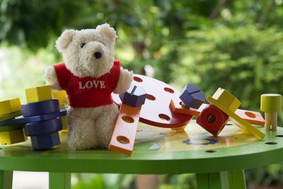 Toys and teddy bear on table