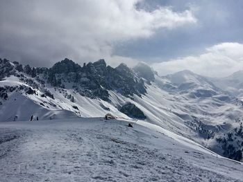 Scenic view of snowcapped mountains against cloudy sky