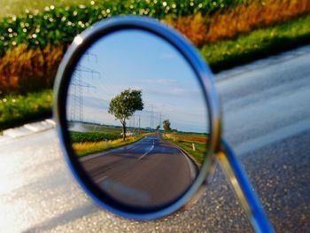 Reflection of road on side-view mirror of car