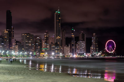 Illuminated buildings against sky at night