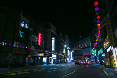 Illuminated city street and buildings at night