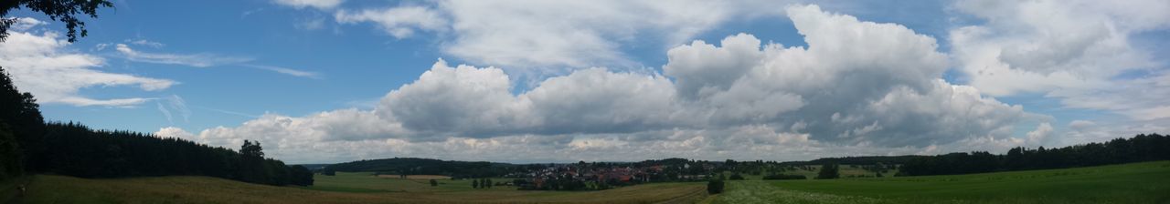 Panoramic view of agricultural field against sky