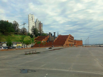 View of modern buildings against cloudy sky