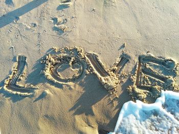 High angle view of text on sand at beach