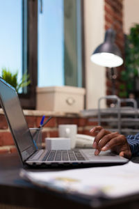 Midsection of woman using laptop on table