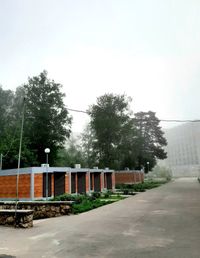 Empty road by building against sky