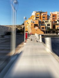 Street amidst buildings in city against clear sky