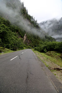 Road by mountains against sky