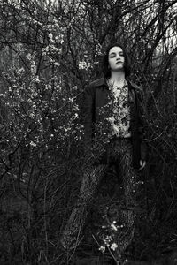 Woman standing by tree in forest