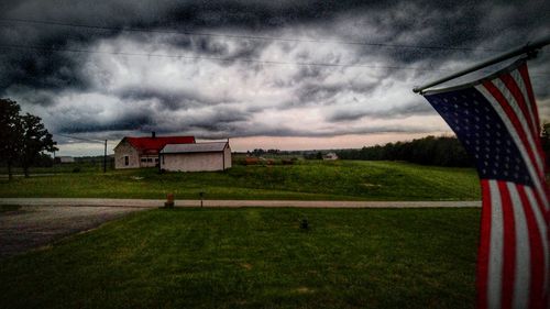 Scenic view of grassy field against cloudy sky