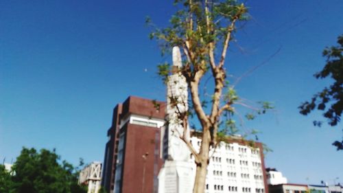 Low angle view of buildings against clear blue sky