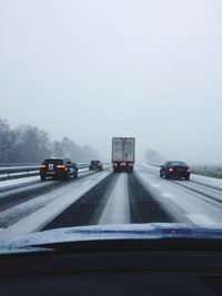 Cars on road against sky during winter