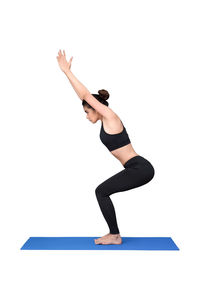 Woman with arms raised against white background